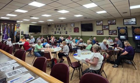 Seniors sitting at round tables for lunch. 