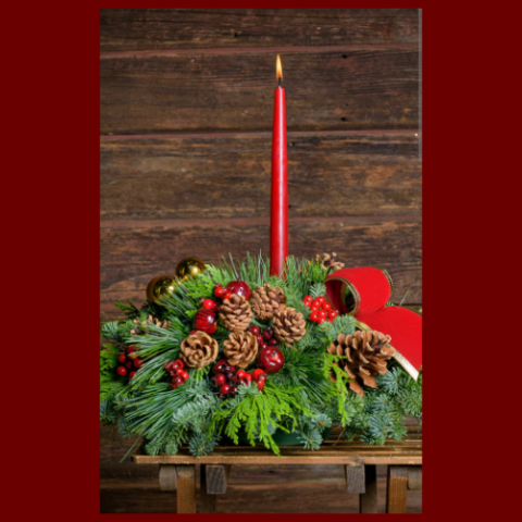 Holiday floral arrangement with red candle lit. 