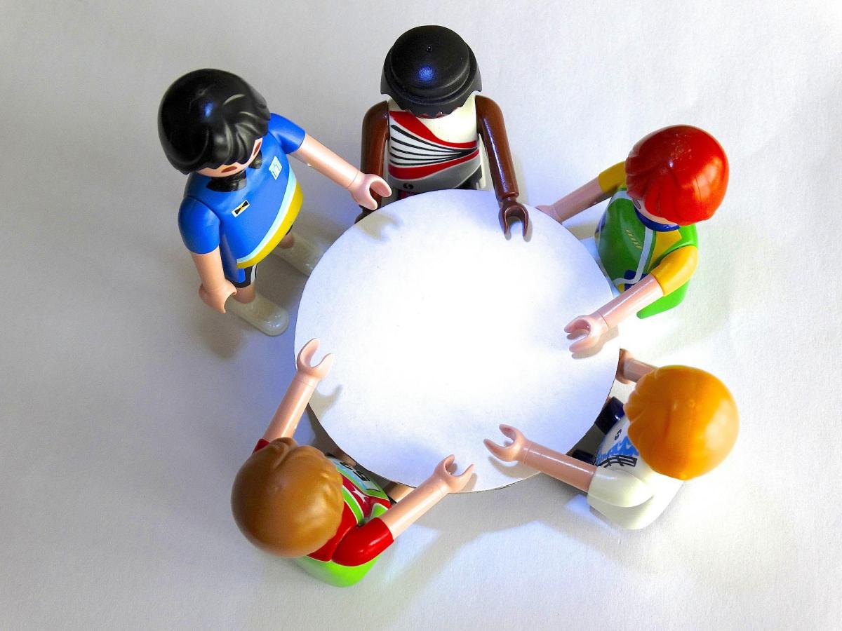 Lego people around a round table. 