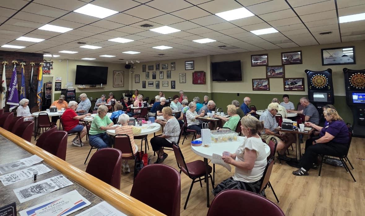 Seniors sitting at round tables for lunch. 