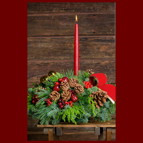 Holiday floral arrangement with red candle lit. 