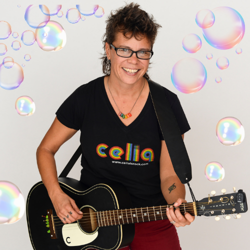 Celia Shacklett's holding guitar and surrounded by bubbles. 